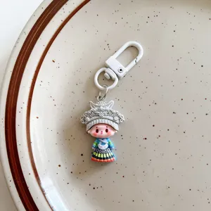 Cute ethnic style girl keychain detail shot, unique resin doll pendant for student bags and gifts.