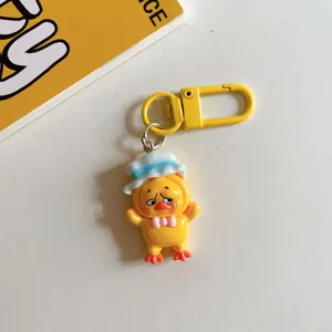 Vue détaillée de porte-clé canard jaune dessin animé mignon, charmant accessoire de sac en résine.