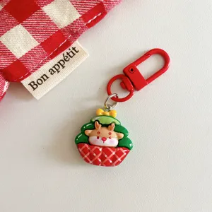Close-up detail of a cute Christmas deer keychain pendant with red metal clasp and design.