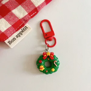 Close-up of the cute Christmas wreath keychain pendant with red clasp and festive details.