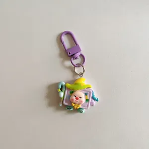 Detailed close-up of a cute cartoon pig dress-up keychain pendant with purple clasp.