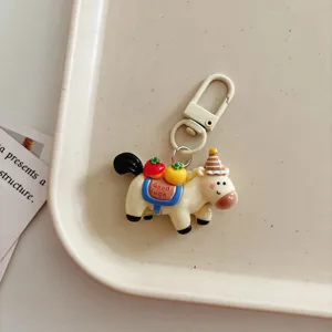 Detail shot of cute cartoon horse keychain with fruit charm and metal clasp pendant ornament.