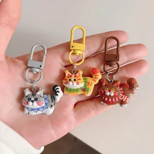 Close-up detail of cute cartoon cat keychains with colorful metal clasps, perfect bag charms.
