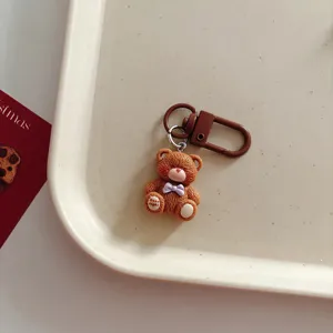 Grazioso portachiavi con orsetto marrone e fiocco viola, bellissimo ciondolo per borsa.