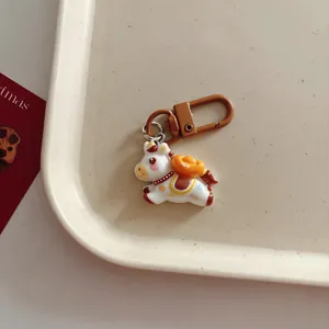 Detailed view of the cute cartoon horse keychain with a gold ingot pendant for bags and keys.