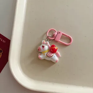 Cute pink cartoon horse keychain with red bag, stylish bag charm and creative accessory.