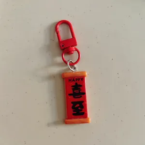 Gros plan détaillé du porte-clés rouleau rouge chinois avec des caractères festifs et un crochet.