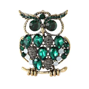 Broche hibou vintage exquise avec des strass verts et clairs scintillants, détail de bijoux.