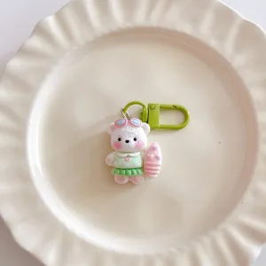 Detailed close-up of a cute surfing bear keychain on a white plate, perfect bag accessory.