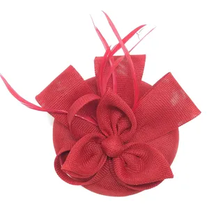 Vista detallada de sombrero fascinator rojo, con elegante lazo de malla y plumas delicadas.