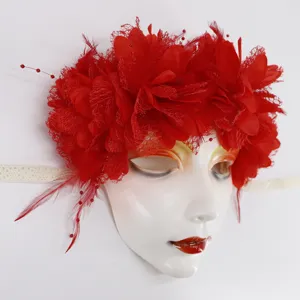 Detailaufnahme der weißen Maskenball Maske mit roten Blumen und Federn für Kostümpartys.
