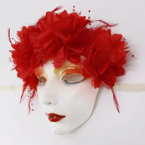 Nahaufnahme der roten Blumen-Masken-Details mit zarten Netztblumen und Federnoptik.