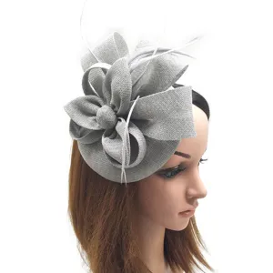 Vista detallada de un elegante sombrero fascinador plateado con flores de malla y plumas blancas.