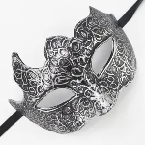 Gedetailleerde close-up van een vintage zilveren masker met sierlijke wijnranken