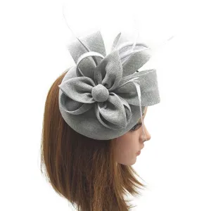 Vista detallada del elegante sombrero fascinador gris con flor de malla y plumas blancas.