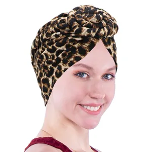 Primer plano de un elegante turbante con estampado de leopardo y diseño de vórtice retorcido.