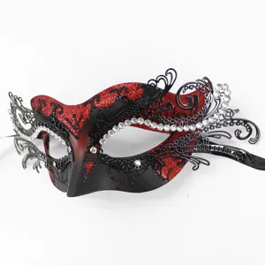 Metall Maskerade Maske Detail mit filigranem Hohl Design, rotem Glitzer und klaren Strasssteinen.