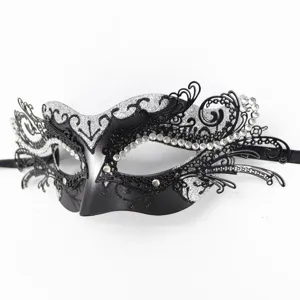 Nahaufnahme der schwarzen Metall-Filigran-Maske mit glitzernden Strasssteinen und Riemen.