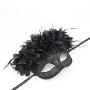 Vista detallada de la máscara de mascarada negra con plumas, encaje y flores negras.