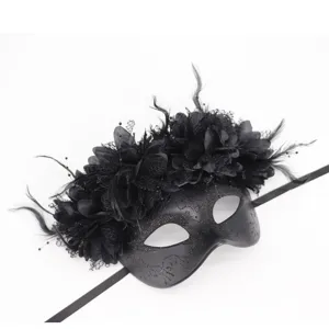 Vista detallada de la máscara de mascarada negra con plumas delicadas, flores de encaje y brillos.