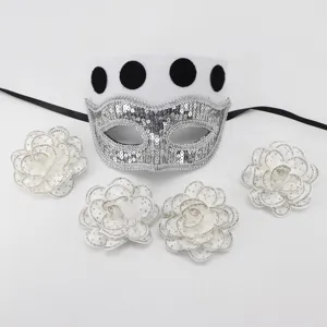 Close-up detail of white masquerade mask with silver sequins and detachable rhinestone flower accessories.