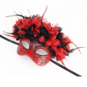 Vista detallada de la máscara de mascarada roja y negra con plumas, encaje y flores decorativas.