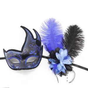 Vista detallada de máscara de mascarada azul y negra con plumas y flores artificiales para fiesta.