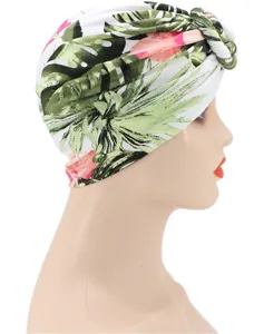 Detalle de primer plano de turbante con estampado de hojas tropicales y nudo elegante en tela suave.