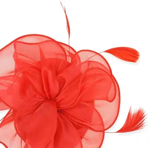 Close-up detail of red organza fascinator hat with elegant feathers for party and cocktail.