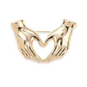 Gold hand heart brooch detail, stylish minimalist fashion accessory for apparel decoration.