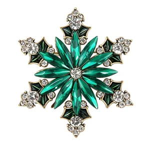 Nahaufnahme der Vintage grünen Strass-Schneeflocken-Brosche, glänzende Kristallakzente.