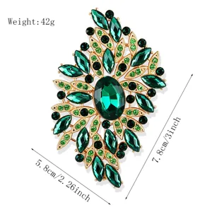 Detailansicht der großen grünen Strass-Brosche mit filigranen Blättern und funkelnden Steinen.