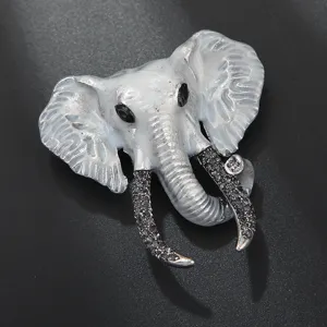 Vintage elephant brooch detailed view, white enamel and sparkling rhinestones on silver metal.