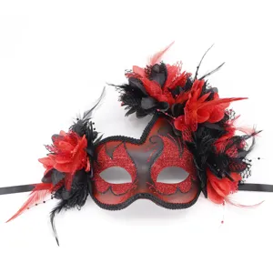 Gedetailleerde close-up van rood-zwarte feestmasker met elegante veren en kanten decoratie.