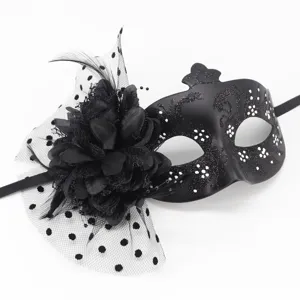 Close-up detail of black masquerade mask with fabric flower and polka dot mesh veil