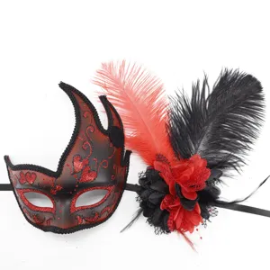 Detalle de máscara con motivos de purpurina roja, bordes de encaje negro y flores de plumas.