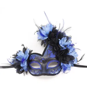 Gedetailleerde close-up van een zwart masquerademasker met blauwe glitter, veren en bloemen.