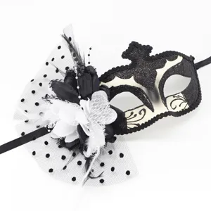 Détail de masque de bal masqué avec plumes noires et blanches, jolies fleurs et résine à pois.