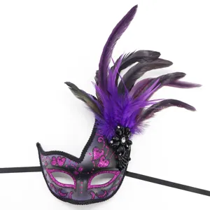 Close-up detail of purple masquerade mask with glitter and black feathers for party.