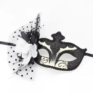 Gros plan détaillé sur l'élégant masque de bal masqué noir et blanc avec plume et joli voile.