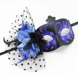Detailed shot of a black masquerade mask featuring blue glitter swans and a floral veil