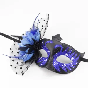 Detail view of black masquerade mask with blue glitter swan, mesh and feathers