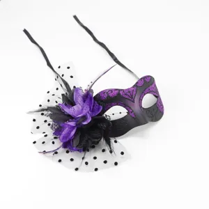 Close-up detail of the black and purple masquerade mask featuring mesh veil, feathers and flowers.