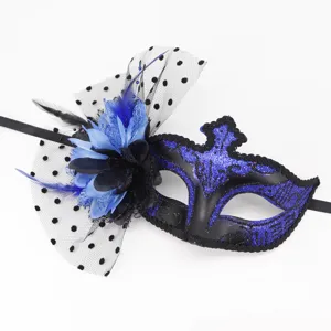Vue rapprochée du masque de bal masqué bleu et noir avec des plumes délicates et un filet à pois.