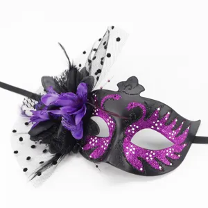 Close-up of black masquerade mask with purple glitter swans and floral veil detail