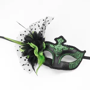 Gros plan détaillé d'un masque de bal masqué noir et vert avec fleurs et plumes.