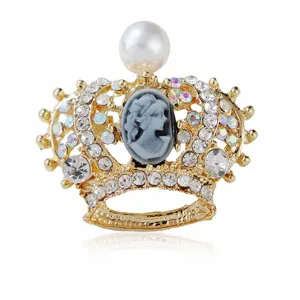 Close-up detail of vintage gold-tone crown brooch featuring rhinestone crystals and cameo.