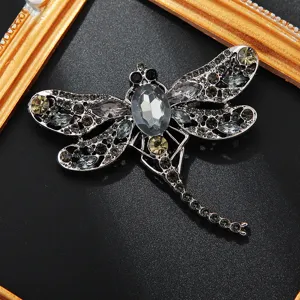 Gedetailleerde close-up van een sprankelende strass libel broche, elegant insect sieraad.