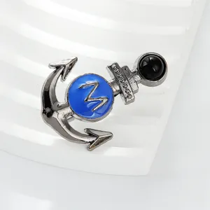 Close-up detail of stylish alloy anchor brooch with blue center and black bead decoration.
