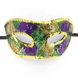 Detailaufnahme einer prunkvollen Karneval Maske mit glitzernden Pailletten in Gold und Gruen.